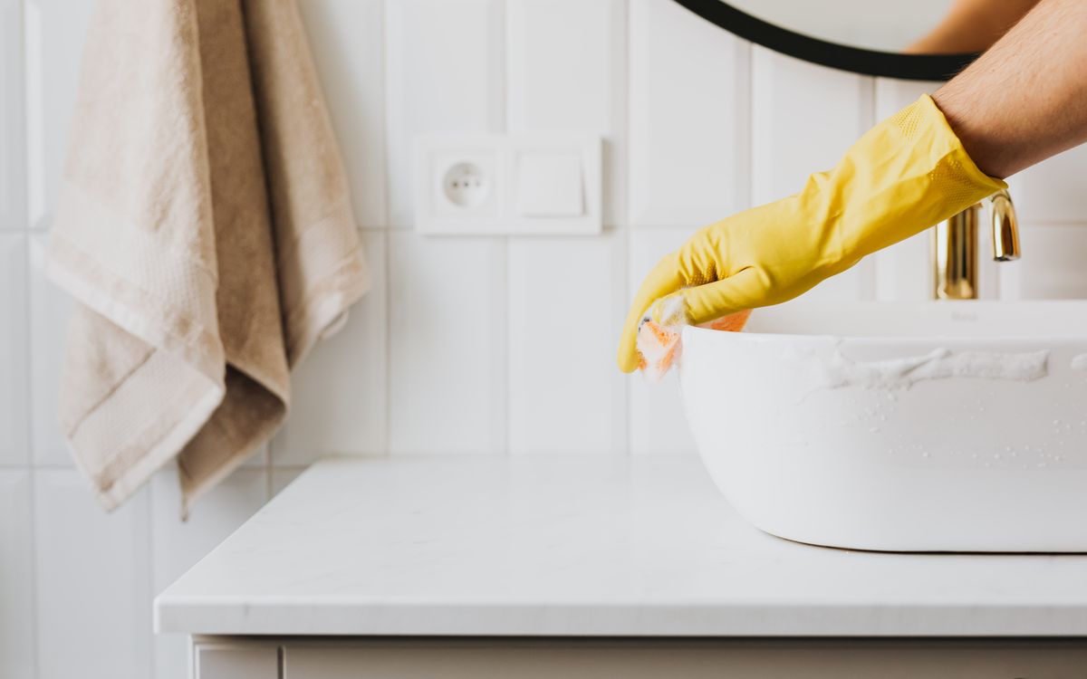 Gloved hands detailing a surface during a post-construction clean