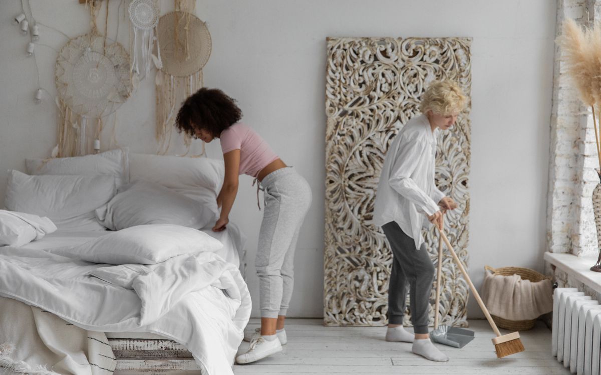 Two Clean2Shine cleaners tidying a bright bedroom